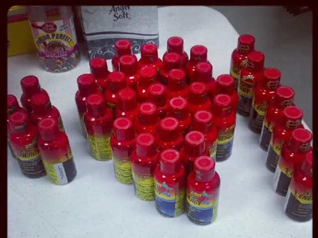 In this picture there are group of bottles on a table and a plastic bottle. The bottles are in red,...