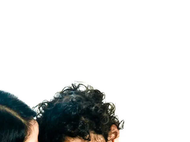 In this picture there is a woman with black dress is standing and holding the kid. At the back...