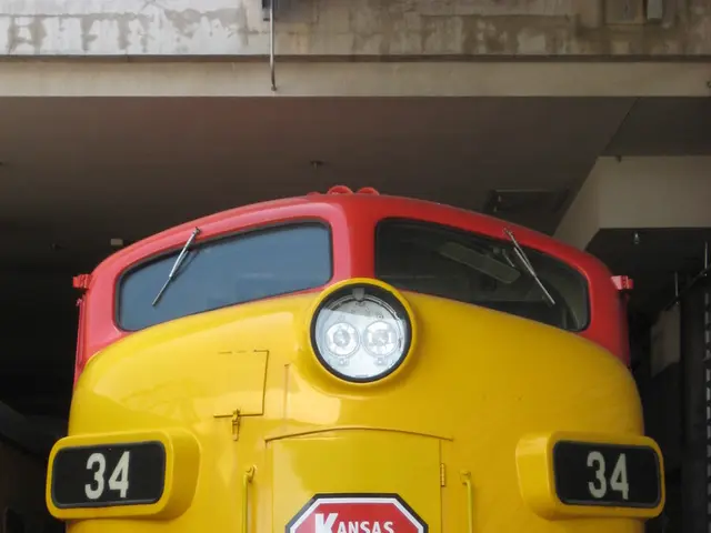 In this image we can see machines, cables, computer display, pen holder, persons and a stress ball.