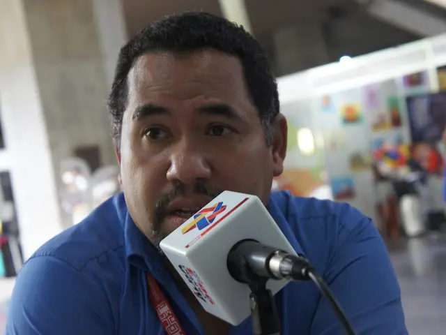 A man is speaking in the microphone, he wore blue color shirt and this microphone is in white...